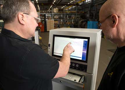 Operating WeldCloud weld monitoring system: a welder using a computer to monitor and control the welding process.